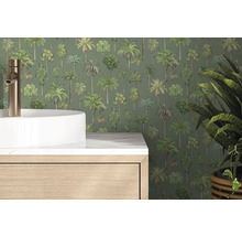 Papier peint intissé avec motif de palmiers dans une salle de bain derrière une vasque à poser blanche et un meuble sous-vasque aspect bois.