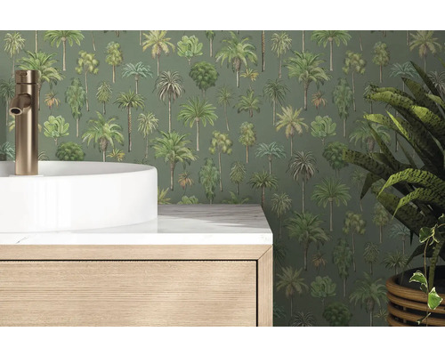 Papier peint intissé avec motif de palmiers dans une salle de bain derrière une vasque à poser blanche et un meuble sous-vasque aspect bois.