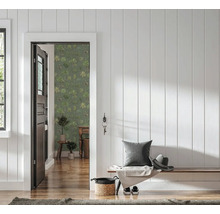 Entrée avec boiseries blanches, banc en bois et porte ouverte sur une pièce avec papier peint vert à motif de palmiers.