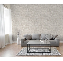 Salon avec papier peint intissé à motif de forêt, canapé gris, table basse et tapis à motifs.