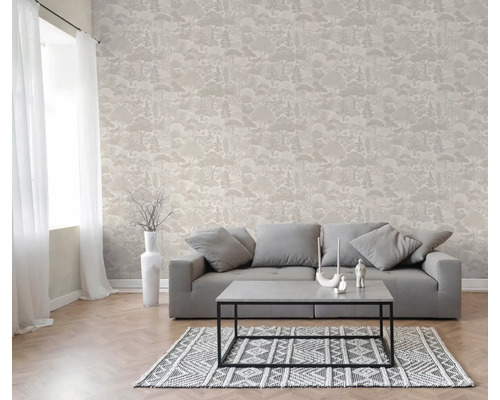 Salon avec papier peint intissé à motif de forêt, canapé gris, table basse et tapis à motifs.