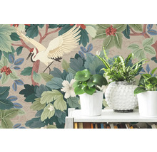 Papier peint intissé avec motif de grue japonaise, grandes feuilles vertes et baies rouges derrière des plantes d'intérieur sur une étagère.