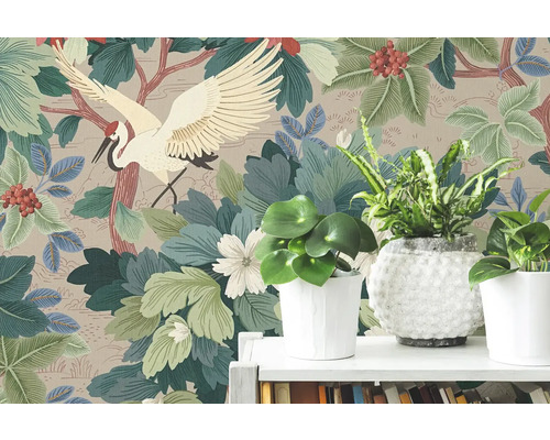 Papier peint intissé avec motif de grue japonaise, grandes feuilles vertes et baies rouges derrière des plantes d'intérieur sur une étagère.