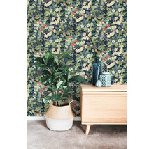 Papier peint intissé avec motif de grues et de fleurs dans une pièce avec un buffet en bois et une plante dans un panier tressé.