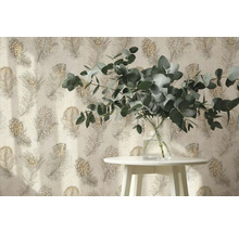 Papier peint intissé avec motif de plumes de paon derrière une table blanche avec des branches d eucalyptus dans un vase en verre.