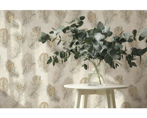 Papier peint intissé avec motif de plumes de paon derrière une table blanche avec des branches d eucalyptus dans un vase en verre.