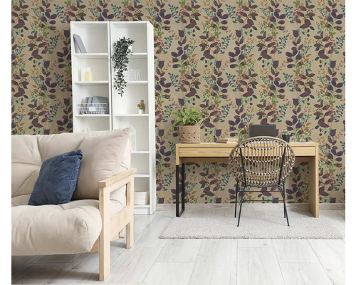 Wohnraum mit botanischer Tapete mit Blättermuster, einem weißen Regal, einem Holzschreibtisch mit Rattanstuhl und einem Sofa in hellen Farben.
