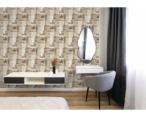 Schlafzimmer mit Vliestapete mit Architekturmuster in Beige, modernem Sessel, weißem Sideboard und asymmetrischem Spiegel.