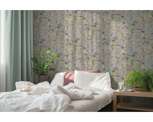 Chambre à coucher avec papier peint intissé floral, lit blanc avec chat, plantes vertes et rideau clair.