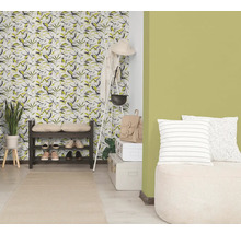 Entrée lumineuse avec papier peint à motif de feuilles, mur peint en vert, étagère à chaussures sombre, vestiaire blanc et tapis clair.