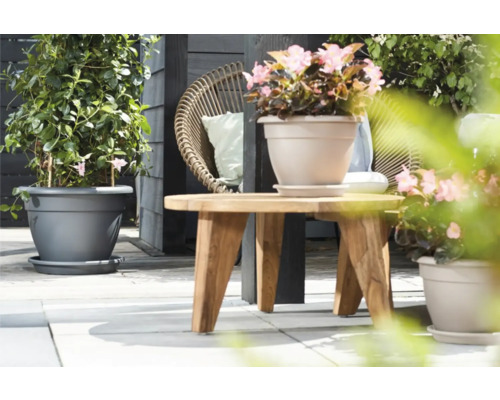 Szene mit bepflanzten Blumentöpfen und einem Holztisch auf einer Terrasse