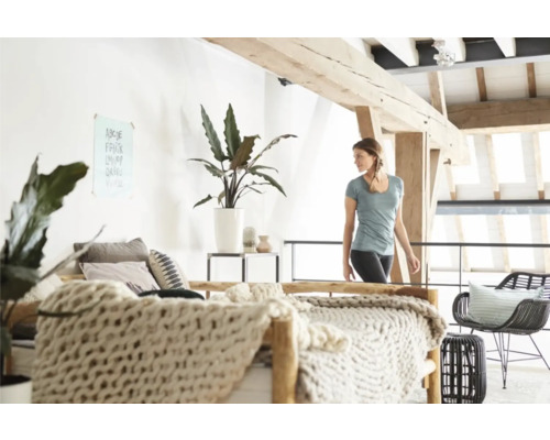 Helles Schlafzimmer mit Doppelbett, Zimmerpflanzen und Holzelementen