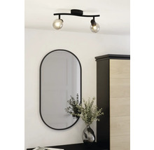 Plafonnier avec deux spots et miroir ovale au-dessus d'une commode