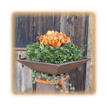 Dekoration mit Blumen in einer Metallschale auf einem Sockel