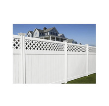 Clôture de jardin blanche avec lattes et éléments décoratifs devant une maison