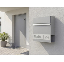 Grauer Briefkasten mit Zeitungsfach an einer Hauswand neben einer Tür