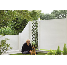 Jardin avec clôture en plastique, treillis et femme assise avec chien