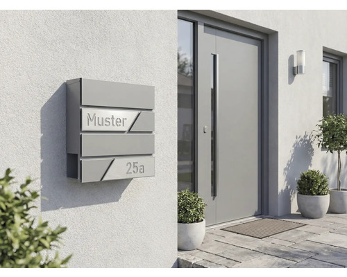 Moderne Briefkastenanlage an einer Hauswand mit der Aufschrift Muster 25a
