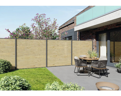 Gartenansicht mit Holzzaun und Sitzgruppe auf einer Terrasse