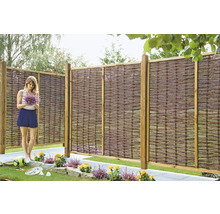 Scène de jardin avec clôture en osier et femme avec bouquet de fleurs