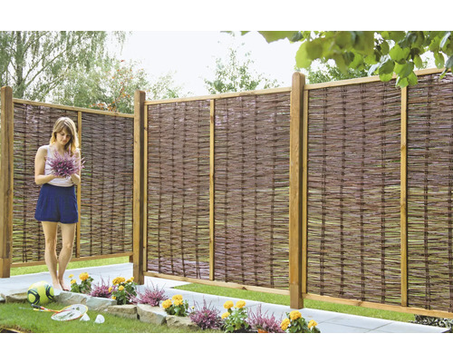 Scène de jardin avec clôture en osier et femme avec bouquet de fleurs