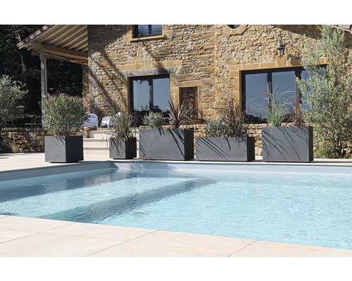 Rangée de jardinières de différentes tailles à côté d'une piscine dans un jardin.