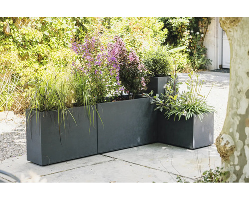 Pflanzgefäße aus Metall mit verschiedenen Pflanzen im Außenbereich