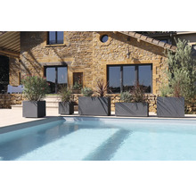 Szene mit mehreren grauen Pflanzgefäßen unterschiedlicher Größe neben einem Swimmingpool.