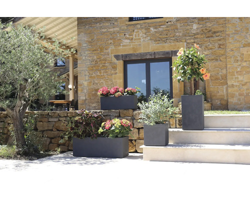 Pots de fleurs décoratifs en grès avec des plantes florales dans un jardin