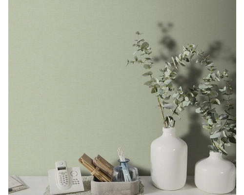 Gros plan d'un papier peint à motifs subtils dans une pièce lumineuse avec des éléments décoratifs.