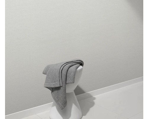 Couverture grise sur un tabouret blanc dans une salle de bain