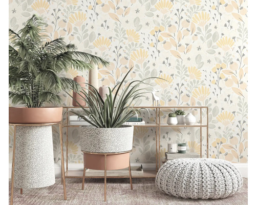 Dekoratives Interieur mit Zimmerpflanzen, Regal und Pouf vor einer floralen Tapete