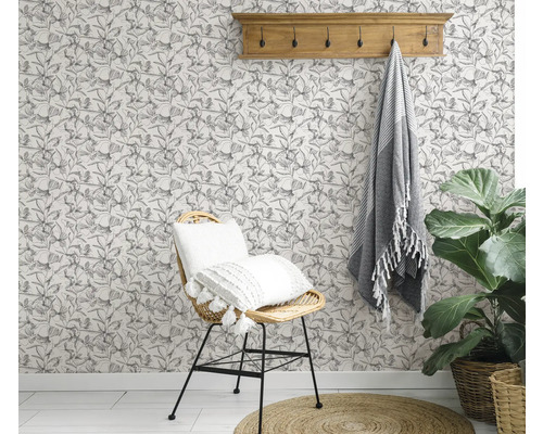 Pièce décorée avec une chaise, une serviette, une plante et un papier peint floral