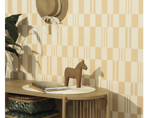 Scène décorative avec table, livres, cheval en bois et chapeau au mur