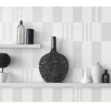 Vases décoratifs sur étagères blanches devant un mur à motifs