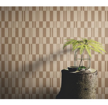 Papier peint à motif géométrique, agencé avec une souche d'arbre comme table et une plante dans un vase.
