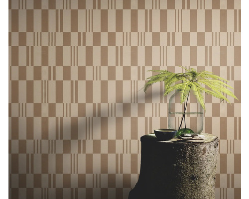 Papier peint à motif géométrique, agencé avec une souche d'arbre comme table et une plante dans un vase.