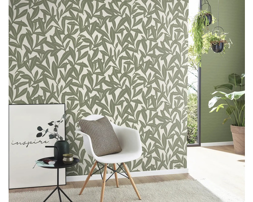 Pièce avec papier peint à motifs de feuilles, chaise et décoration pour une ambiance élégante.