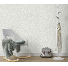 Vue d'une pièce avec papier peint à motifs de feuilles, fauteuil à bascule, portemanteau et sac