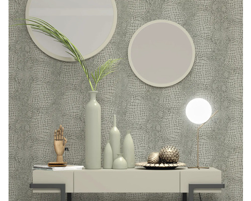 Scène décorative avec papier peint aspect cuir de crocodile, miroirs ronds, lampe de table et vases sur une commode