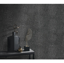 Gros plan d'un mur avec du papier peint en cuir de reptile et de la décoration sur une table