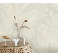 Papier peint à motif de feuilles en arrière-plan, table avec décoration au premier plan.