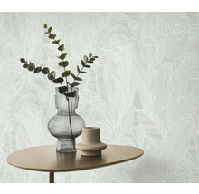 Gros plan d'un mur avec du papier peint à motifs de feuilles, table avec vases