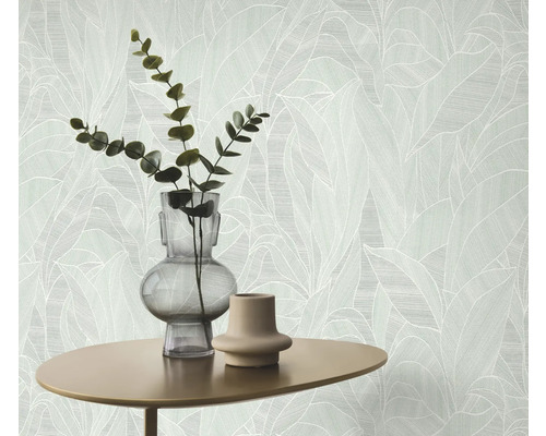 Gros plan d'un mur avec du papier peint à motifs de feuilles, table avec vases