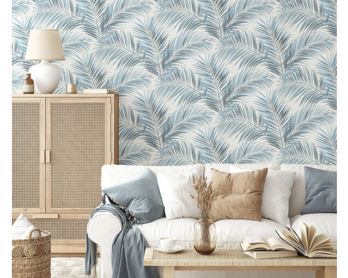 Salon avec canapé, table et armoire devant un papier peint à motif de palmier