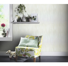 Scène avec fauteuil à motifs, étagère et papier peint rayé