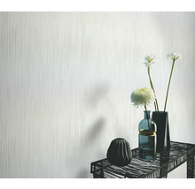 Papier peint clair avec motif à rayures verticales dans un salon avec des vases de fleurs sur une table