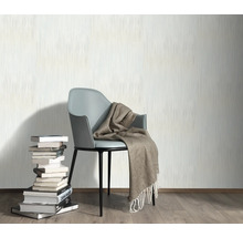 Décoration murale avec papier peint, chaise, couverture et pile de livres pour une ambiance chaleureuse