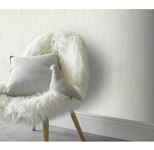 Intérieur décoratif avec un papier peint texturé, une chaise recouverte de fourrure et un coussin