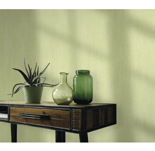 Nature morte décorative avec plante, vases et console devant un mur